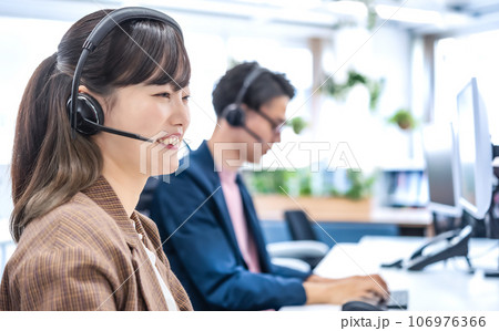 フリーアドレスのオフィスで仕事をするビジネスマンとビジネスウーマン フリーアドレスのオフィスで仕事をするビジネスマンとビジネスウーマン 106976366