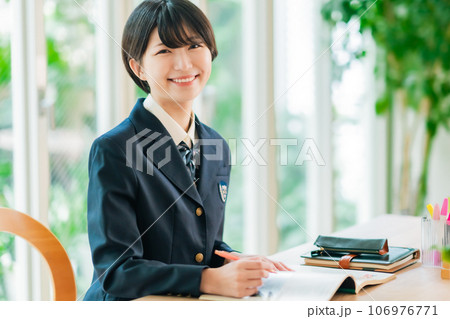 資料を広げて微笑む女子高生 106976771