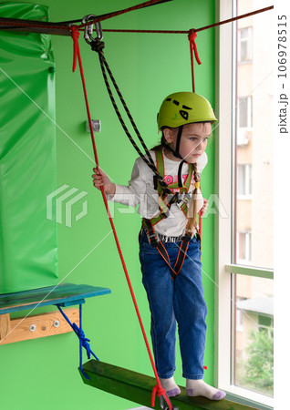 Children's cableway in the playroom, little girl passes the cableway. Children's cableway in the playroom, little girl passes the cableway. 106978515