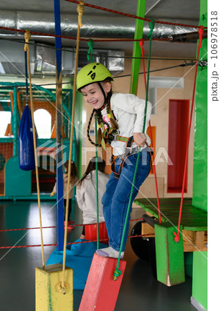 Happy girl passes the cableway, active recreation in the game room. 106978518