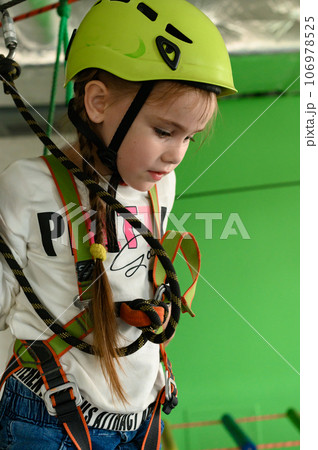 A little girl walks on a cableway, a playroom with a cable car. 106978525