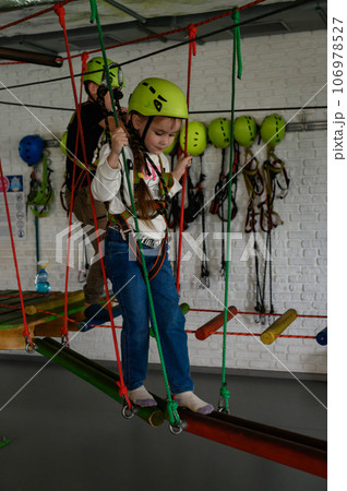 A little girl walks on a cableway, a playroom with a cable car. 106978527