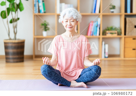 リビングでヨガをするシニア女性。 106980172