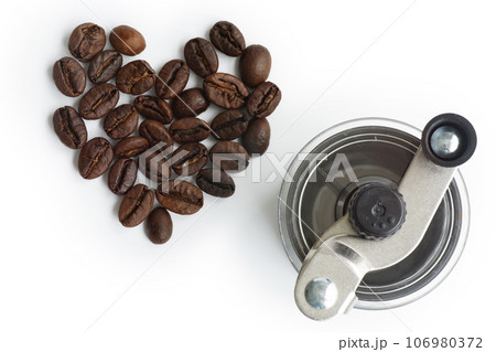 Grinding coffee beans in a manual coffee grinder on isolate white background Grinding coffee beans in a manual coffee grinder on isolate white background 106980372