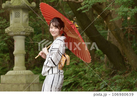 和傘を手に浴衣を着た若い女性 106980639