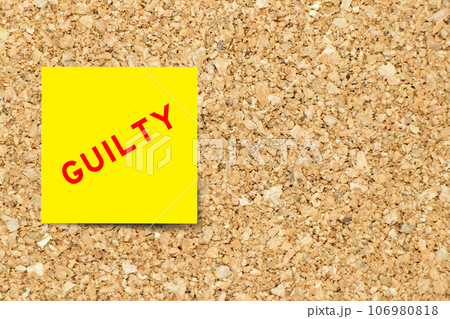 Yellow note paper with word guilty on cork board background with copy space 106980818