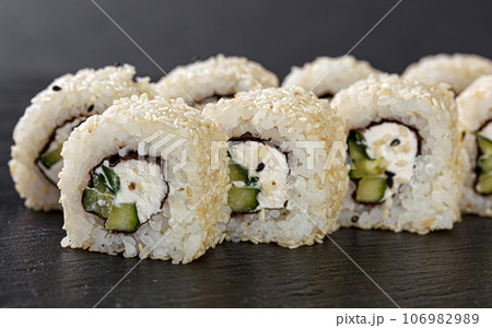 Sushi with salmon on a white plate with wasabi, ginger, soy, chopsticks on a black background 106982989