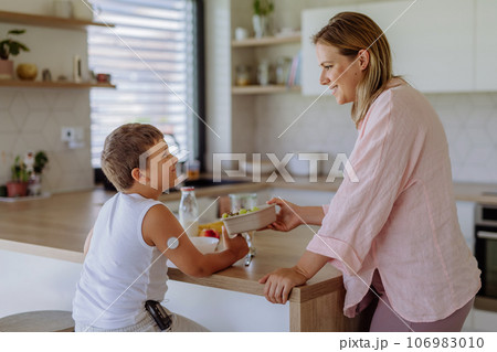 Diabetic boy with a continuous glucose monitor is careful with his diet. 106983010