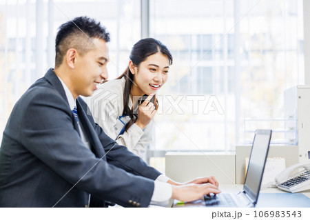 オフィスで同僚と話をするビジネスパーソン オフィスで同僚と話をするビジネスパーソン 106983543