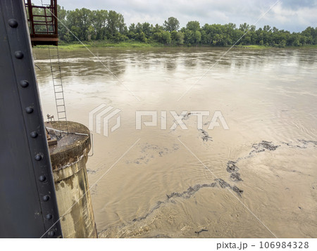 debris floating on the rising Missouri River seen from an old railroad bridge in Boonville, MO 106984328