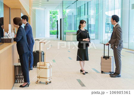 ホテルのフロントでチェックインをするビジネスパーソン ホテルのフロントでチェックインをするビジネスパーソン 106985361
