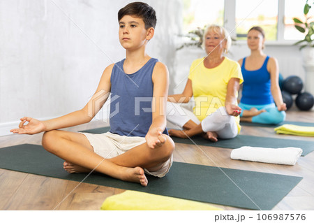 Family three generations do half lotus position Sidhasana with hands clasped in mudra of knowledge Family three generations do half lotus position Sidhasana with hands clasped in mudra of knowledge 106987576