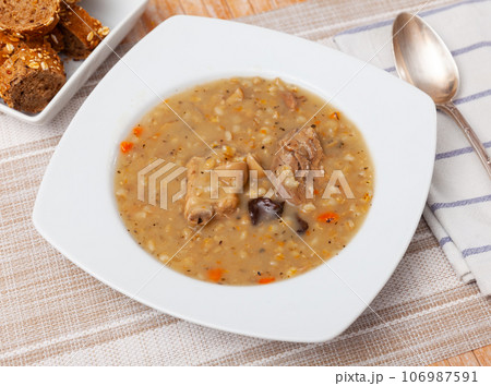Pearl barley soup with pork and mushrooms 106987591