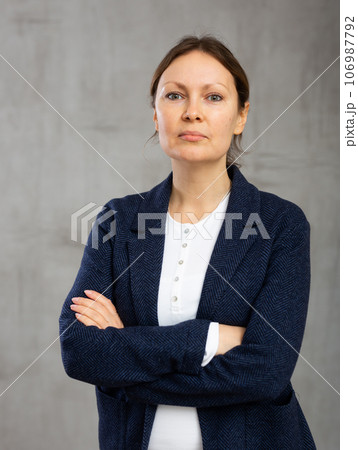 Relaxed calm woman standing and looking forward in front of her Relaxed calm woman standing and looking forward in front of her 106987792
