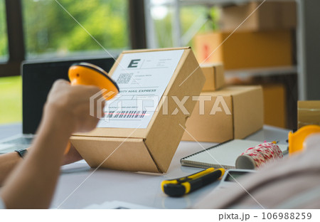 online small business owner scans a barcode-labeled parcel with a barcode scanner to verify a customer's order before it is delivered to the customer. online small business owner scans a barcode-labeled parcel with a barcode scanner to verify a customer's order before it is delivered to the customer. 106988259
