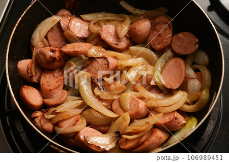 魚肉ソーセージとタマネギをフライパンで炒めている様子 106989451