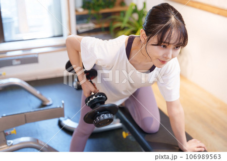 スポーツジムのダンベルで筋トレする女性 スポーツジムのダンベルで筋トレする女性 106989563
