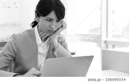 パソコン前で悩む・困る女性会社員モノクロイメージ パソコン前で悩む・困る女性会社員モノクロイメージ 106990554