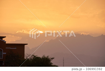 Sunset landscape with remote hotel complex against dark mountain peaks in egyptian desert Sunset landscape with remote hotel complex against dark mountain peaks in egyptian desert 106991392