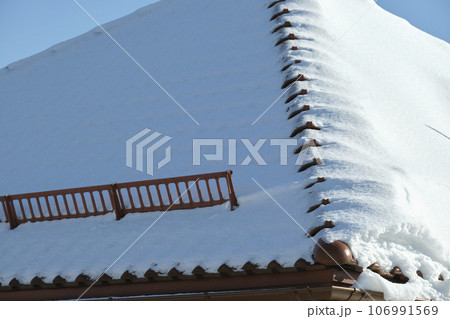 Snow guard for safety in winter on house roof top covered with steel shingles. Tiled covering of building 106991569