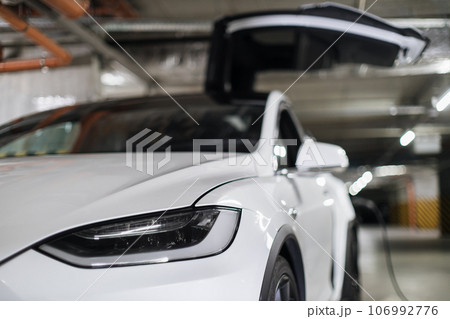 EV being parked with open wing door in charging session EV being parked with open wing door in charging session 106992776