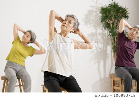 シニアヨガ・椅子ヨガをする60代の女性 106993718