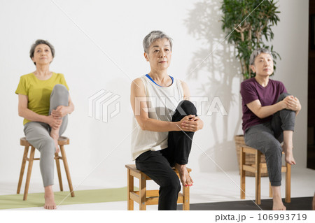 シニアヨガ・椅子ヨガをする60代の女性 106993719