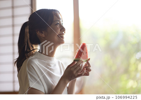 実家でスイカを食べる女性 106994225