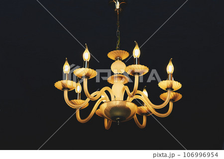 Yellow chandelier with candle lamps isolated on black 106996954