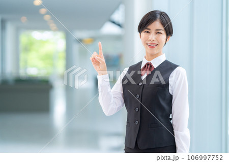 ロビーで案内する若い受付嬢 106997752