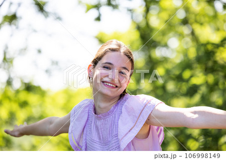 Radiant Laughter: Young Millennial Woman's Joyful Forest Portrait 106998149