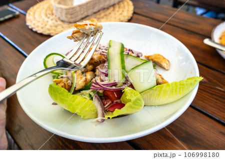 Caesar Salad Closeup, Grilled Chicken Salat with Parmesan Cheese, Greens, Dressing and Cucumbers 106998180