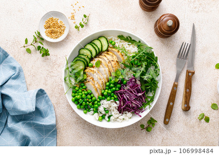 Chicken meat and rice lunch bowl with green peas, red cabbage, cucumber and fresh arugula salad Chicken meat and rice lunch bowl with green peas, red cabbage, cucumber and fresh arugula salad 106998484