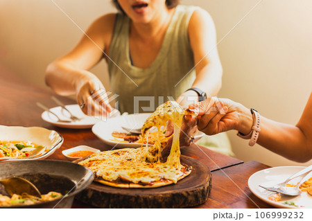 Woman hands taking slices of pizza with friends. 106999232