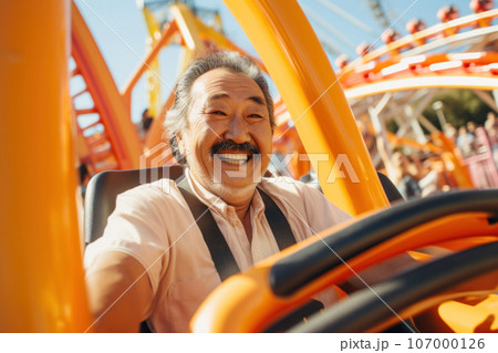 A cheerful elderly chinese asian man with a white beard rides a roller coaster 107000126