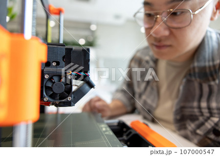 Man checking 3d printer, process of making things on 3d printer in laboratory. Man checking 3d printer, process of making things on 3d printer in laboratory. 107000547