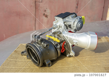 new turbine for an automobile engine lies on the hood of the car new turbine for an automobile engine lies on the hood of the car 107001827