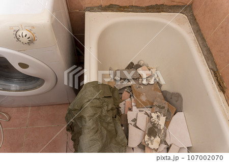 an old dirty shabby bathroom with fallen tiles. repair an old dirty shabby bathroom with fallen tiles. repair 107002070