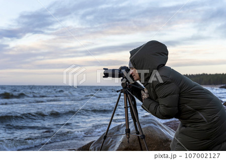 female photographer takes pictures with a camera  107002127