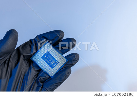 computer processor in a gloved hand on a white background 107002196