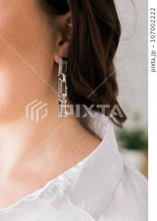 Detail of young woman wearing beautiful luxury earring. Handmade jewellery and accessories 107002222