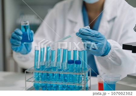 Scientist mixing chemical liquids in the chemistry lab. Researcher working in the chemical laboratory. Scientist mixing chemical liquids in the chemistry lab. Researcher working in the chemical laboratory. 107002302