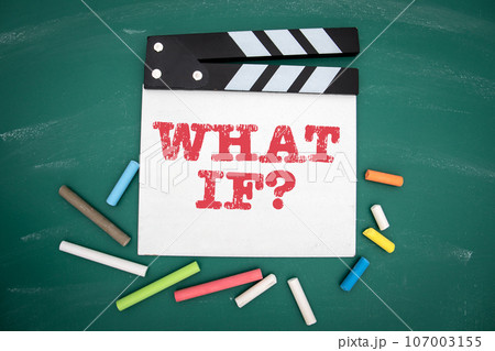 What If. Movie clapper and colored pieces of chalk on a green chalkboard background What If. Movie clapper and colored pieces of chalk on a green chalkboard background 107003155