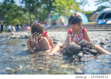 自然の河川プールで水遊びをする姉妹 自然の河川プールで水遊びをする姉妹 107004611
