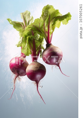 Fresh beets with leaves and splashes fly in the air on blue pastel background. 107005261