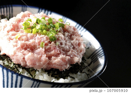 刻み海苔とネギトロの丼ぶりを黒背景で撮影 107005910