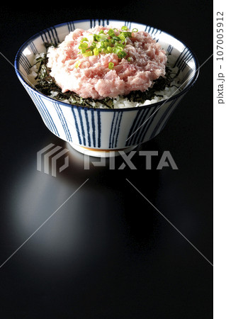 刻み海苔とネギトロの丼ぶりを黒背景で撮影 107005912