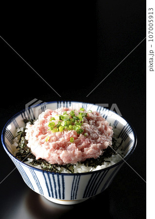 刻み海苔とネギトロの丼ぶりを黒背景で撮影 107005913