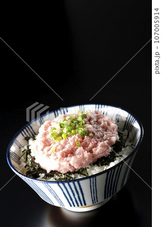 刻み海苔とネギトロの丼ぶりを黒背景で撮影 107005914