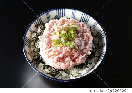 刻み海苔とネギトロの丼ぶりを黒背景で俯瞰撮影 107006004